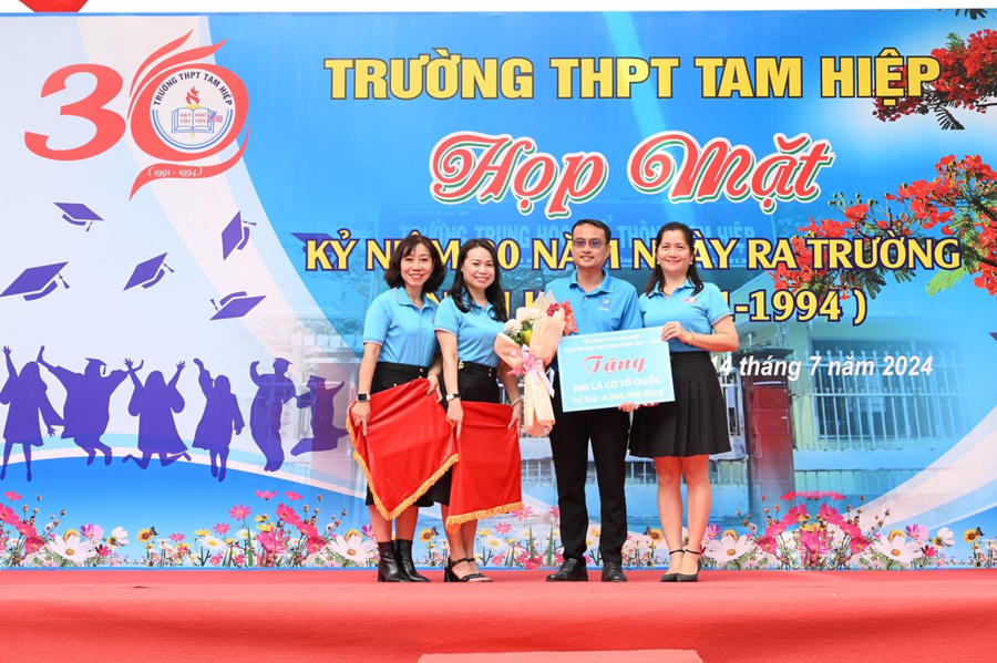 Các cựu học sinh trao tặng cờ tổ quốc.