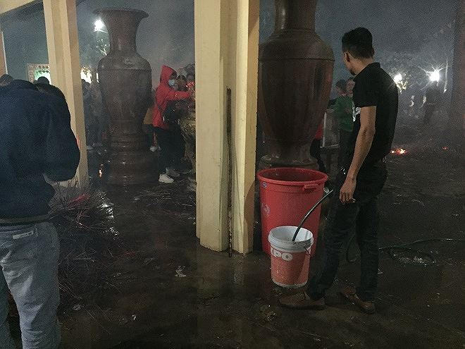 Ban tổ chức luôn túc trực tưới ướt nền và nhang sau khi được hóa để tránh hỏa hoạn.