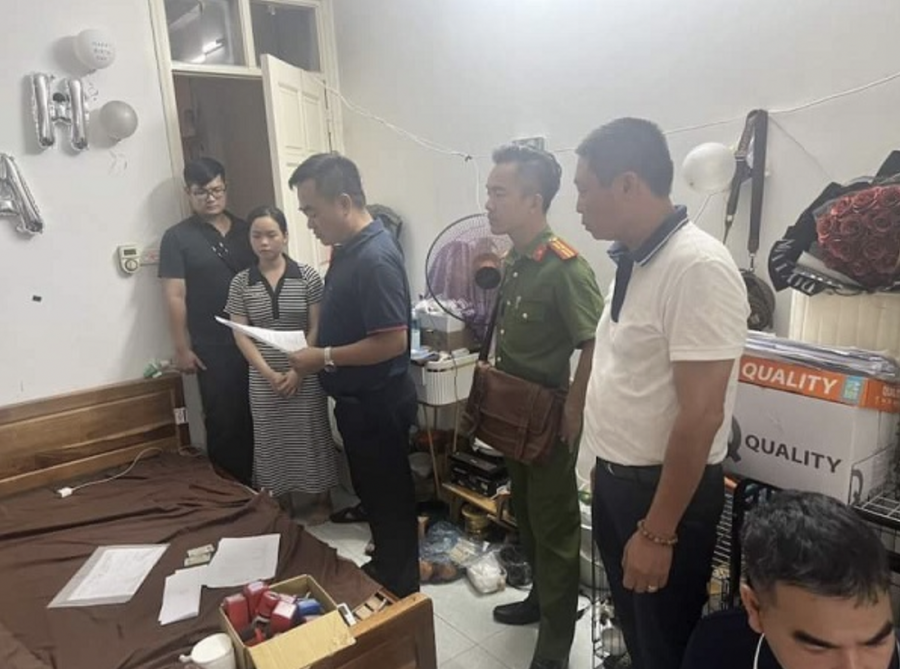Lực lượng chức năng đọc lệnh bắt khẩn cấp 2 đối tượng. Ảnh: Hà nội mới