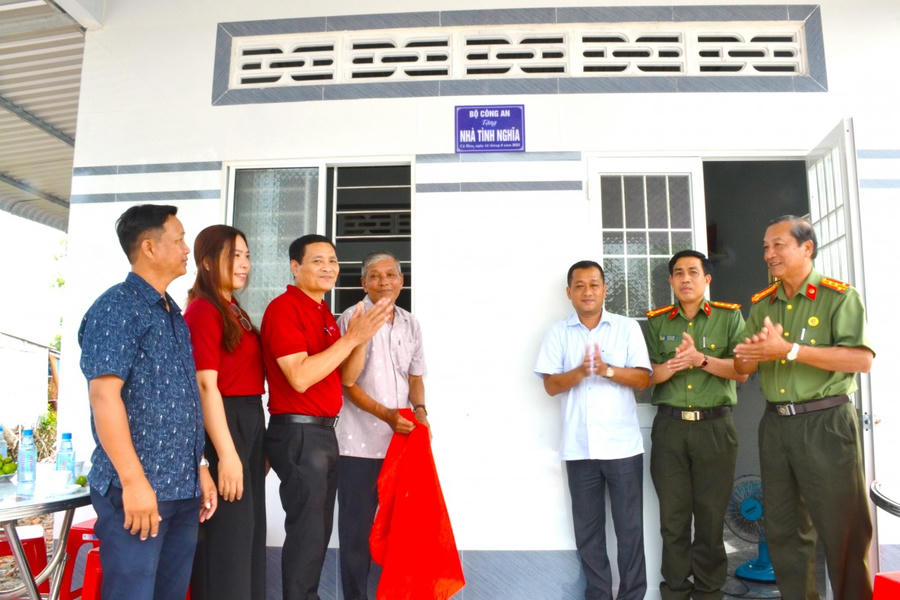 Đại tá Lê Tấn Vinh (thứ 2 từ phải sang) cùng ông Nguyễn Bình Em gắn biển lưu niệm Bộ Công an tặng Nhà tình nghĩa tại buổi lễ.