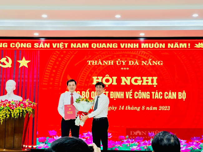 Bì thư Quận ủy Hải Châu Trần Thắng Lợi (bên phải) tặng hoa chúc mừng ông Huỳnh Văn Nhạn.