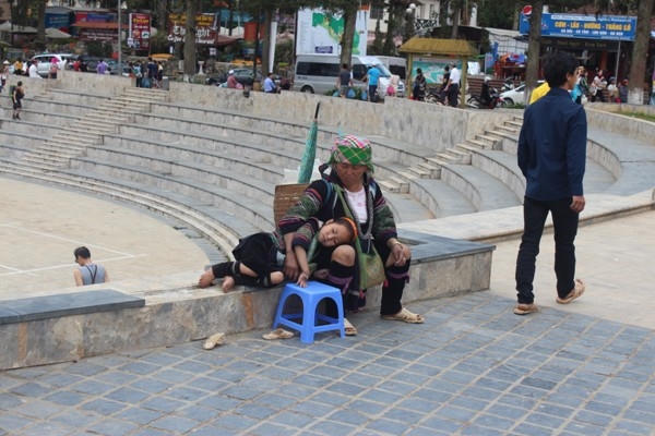 Cô nhóc gối đầu lên mẹ ngủ ngon lành ngoài đường.