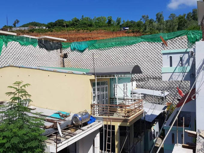 Tường thành khổng lồ nằm trên sườn núi, ngay trên đầu nhà dân.