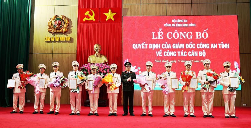Đại tá Đinh Việt Dũng, Giám đốc Công an tỉnh trao quyết định và tặng hoa chúc mừng các đồng chí nghỉ công tác, hưởng chế độ hưu trí và nghỉ công tác chờ hưởng chế độ hưu trí trước hạn tuổi.