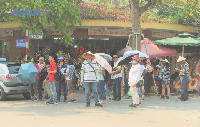Khách du lịch cũng trong những trang phục kín mít và đầy đủ mũ, nón, ô che nắng khi đến với Hà Nội