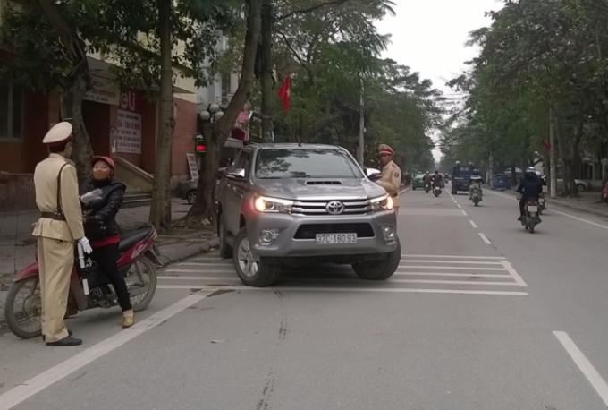 Lực lượng chức năng nhắc nhở để người dân hiểu việc thí điểm đường một chiều trên đường Đinh Công Tráng (Ảnh: Duy Ngợi).