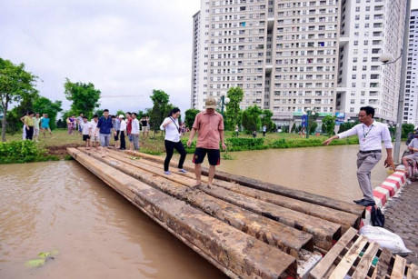 Sau mỗi trận mưa, ban quản lý tòa nhà phải bố trí xe tải, xe ba gác chở người dân và phương tiện ra đường lớn để vào trung tâm thành phố. Theo dự báo, tình hình chưa được cải thiện nhiều trong mùa mưa bão năm nay. Ảnh: Lao động Thủ đô.