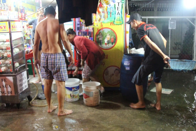 Người dân tranh thủ bắt những con cá trôi theo dòng nước