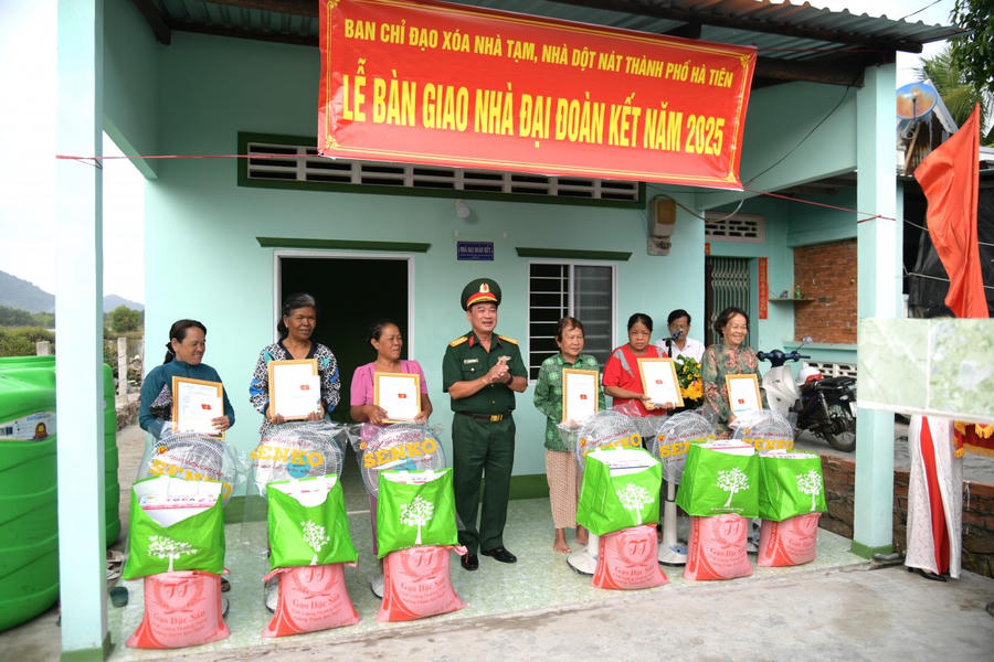 Đại tá Nguyễn Văn Ngành - Ủy viên Ban Thường vụ Tỉnh ủy, Chỉ huy trưởng Bộ CHQS tỉnh Kiên Giang trao tặng quà cho người dân tại lễ bàn giao nhà đại đoàn kết trong chương trình “Xóa nhà tạm, nhà dột nát”