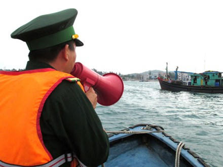 Cán bộ biên phòng kêu gọi tàu thuyền vào tránh bão.