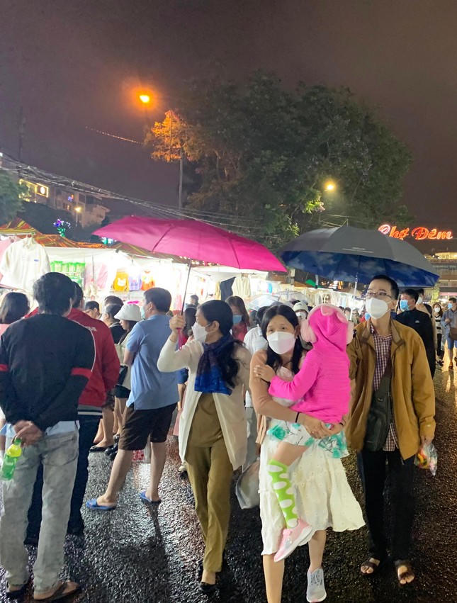 Du khách bung dù che mưa.