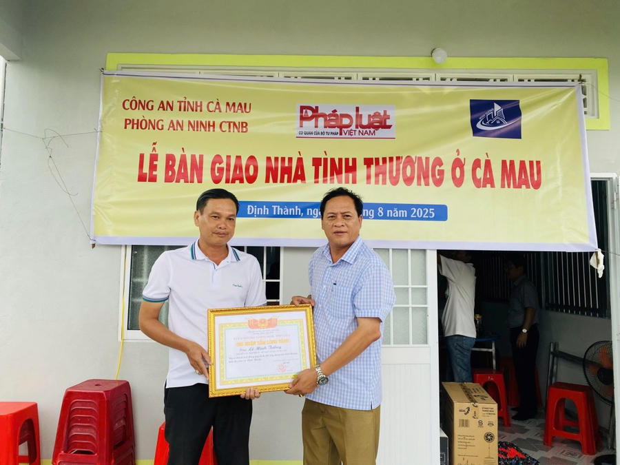 Ông Đỗ Hoàng Liệt - Phó Chủ tịch UBND xã Định Thành (bên phải), trao thư cảm ơn cho ông Lê Minh Tưởng - Giám đốc Công ty TNHH Đầu tư - Xây dựng và San lấp Bạc Liêu - Cà Mau (đơn vị tài trợ).