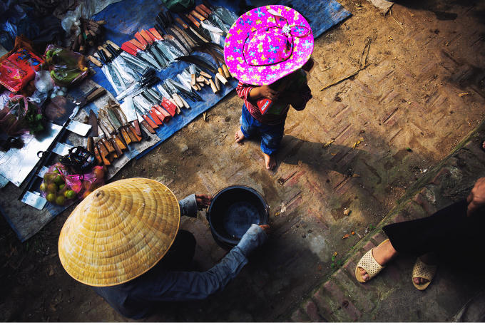 Một người mẹ đi chợ mua cho con trai một món đồ chơi và mua một vài dụng cụ nông nghiệp.
