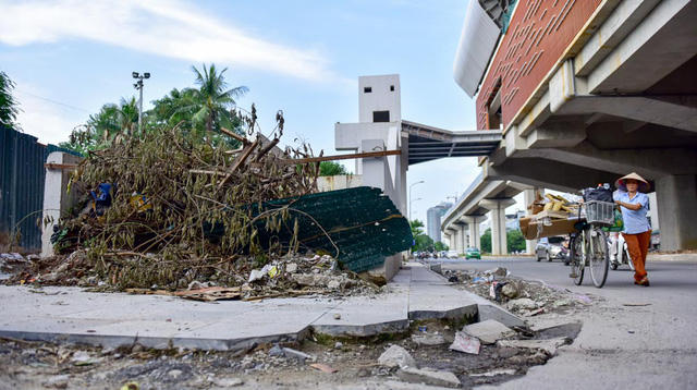Gạch vỉa hè vỡ nát, cành cây ngổn ngang dưới một đoạn đường sắt trên cao.
