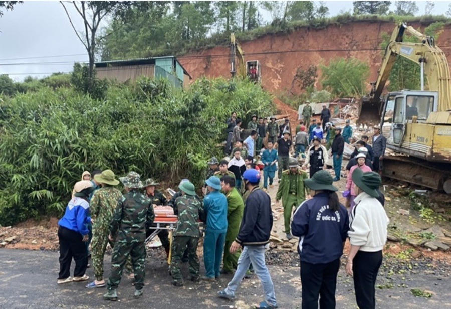 Lực lượng chức năng phối hợp với người dân đưa thi thể nạn nhân ra khỏi hiện trường. (Ảnh: K.L)