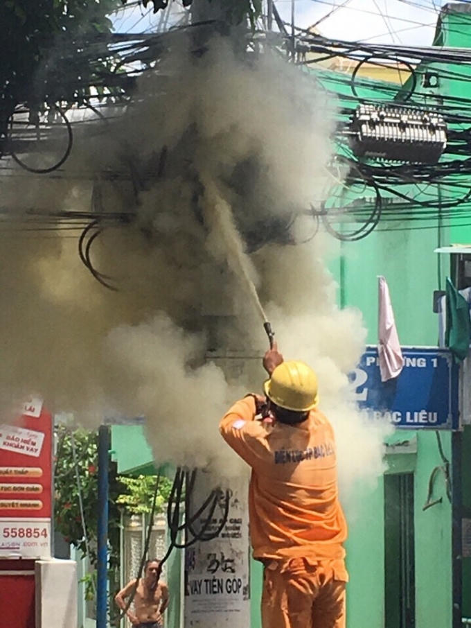 Nhân viên điện lực Bạc Liêu dùng bình cứu hỏa dập tắt đám cháy.