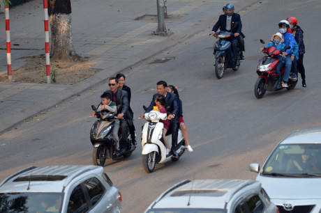 Hai gia đình cùng không đội mũ bảo hiểm vừa đi vừa nói chuyện.