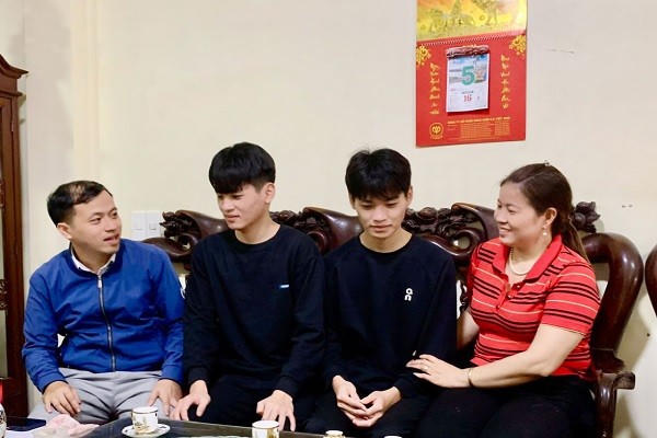 Đại diện Ban Chỉ huy quân sự xã Quang Hưng và người thân trò chuyện, động viên cặp song sinh Vũ Đức Cảnh - Vũ Đức Bình.