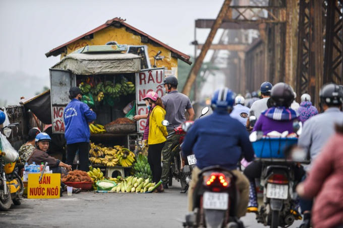 Tuy nhiên, nạn họp chợ trên cầu từ lâu vẫn diễn ra phổ biến. Tại những đoạn làn đường mở rộng ở cả hai hướng, các hàng bán hoa quả bày đầy hàng ra bán. Chỉ cần một người dừng lại mua, phía sau sẽ ùn ứ.