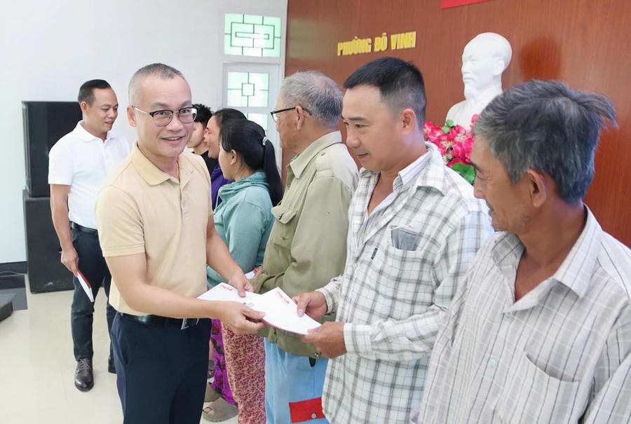 Nhà báo Trần Ngọc Hà – Phó Tổng Biên tập Báo PLVN trao quà cho người dân phường Đô Vinh.