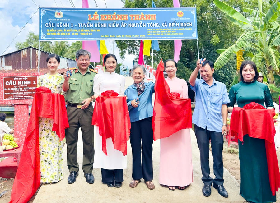 Đại diện Phòng Tham mưu Công an tỉnh Cà Mau, nhà tài trợ và chính quyền địa phương cắt băng khánh thành cầu nông thôn.