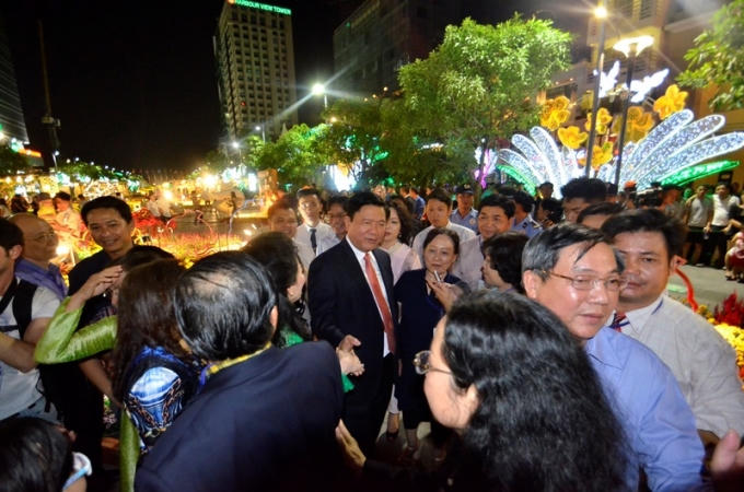 Tân Bí thư Thành Ủy TPHCM, ông Đinh La Thăng được người dân vây quanh xin chụp ảnh và bắt tay sau khi cắt băng khai mạc.