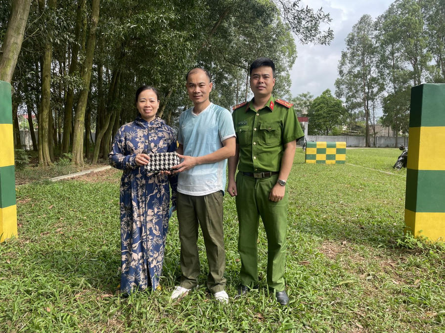 Đại úy Hoàng Hồng Ngọc (giữa) trao trả lại tài sản cho chị Thân Thị Hoa