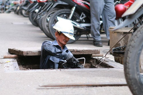 Ông Nguyễn Văn Tuấn đang dọn dẹp rác tại một đoạn cống trên đường Lê Thạch, quận 4, TP HCM