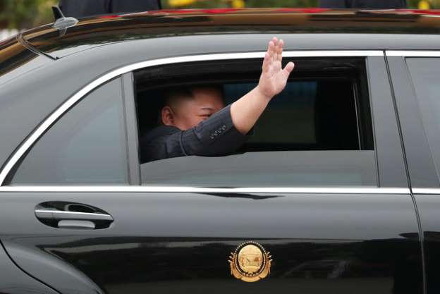 Chủ tịch Triều Tiên Kim Jong Un hạ cửa kính xe, vẫy tay chào người dân Việt Nam.