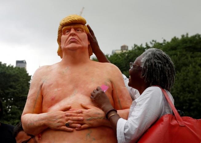 Một phụ nữ thích thú với bức tượng. (Ảnh: Reuters)