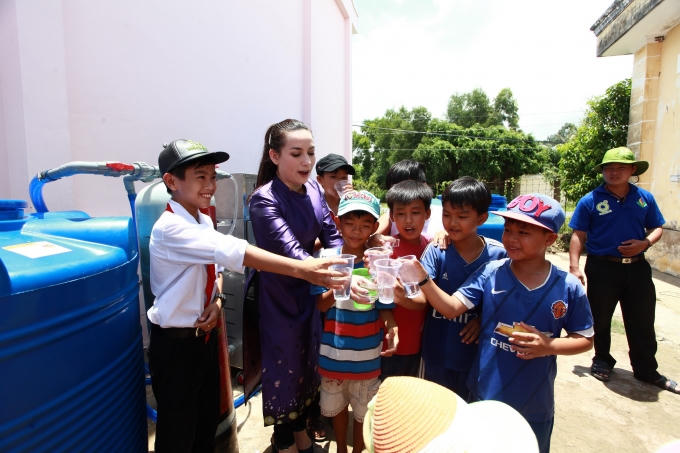 Đại sứ "Hành động nhỏ - Ý nghĩa lớn" cùng các em nhỏ chung vui với những ly nước lấy từ chiếc máy lọc.
