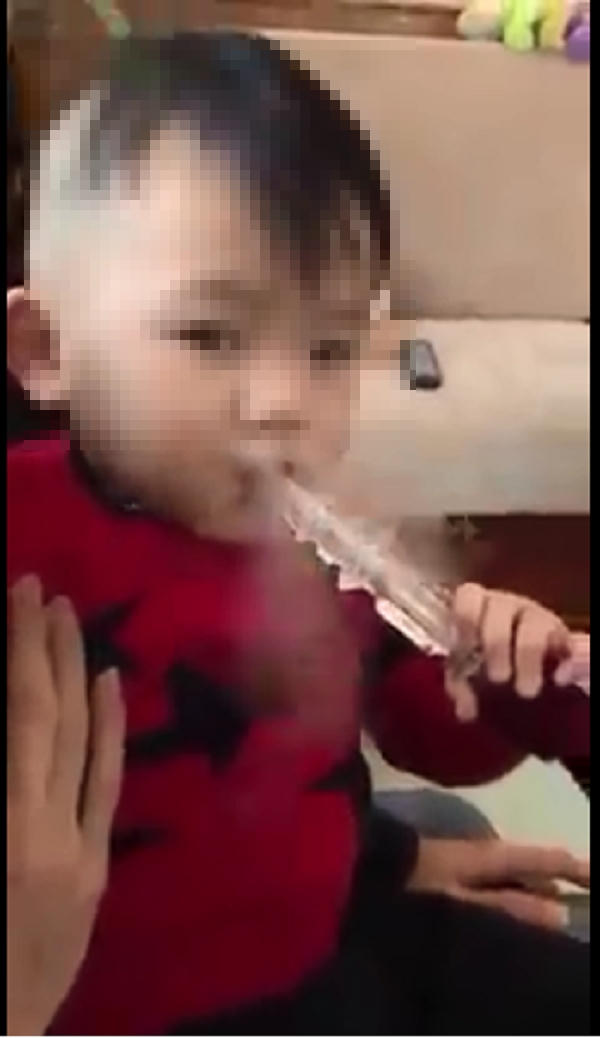 Hình ảnh bé trai bị cho hút Shisha khiến dư luận bức xúc. (Ảnh cắt từ clip).