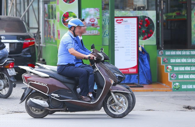 Hai người đàn ông đi xe máy từ trong quán nhậu ra, một người đội mũ bảo hiểm, một người không đội mũ bảo hiểm, đều trong tình trạng