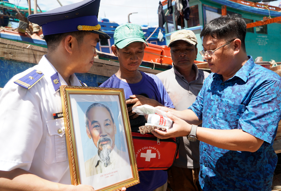 Đại diện Bộ Tư lệnh Vùng Cảnh sát biển 4 và đại diện lãnh đạo địa phương tặng Cờ Tổ quốc, ảnh Bác Hồ và túi thuốc y tế cho ngư dân trên địa bàn xã Dương Hòa, huyện Kiên Lương.
