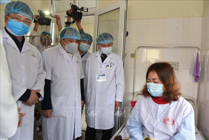 Các bác sĩ thăm hỏi trường hợp phụ nữ bị nghi nhiễm, đang được điều trị tại Trung tâm Bệnh Nhiệt đới, Bệnh viện Hữu nghị đa khoa Nghệ An. Ảnh: Bích Huệ/TTXVN