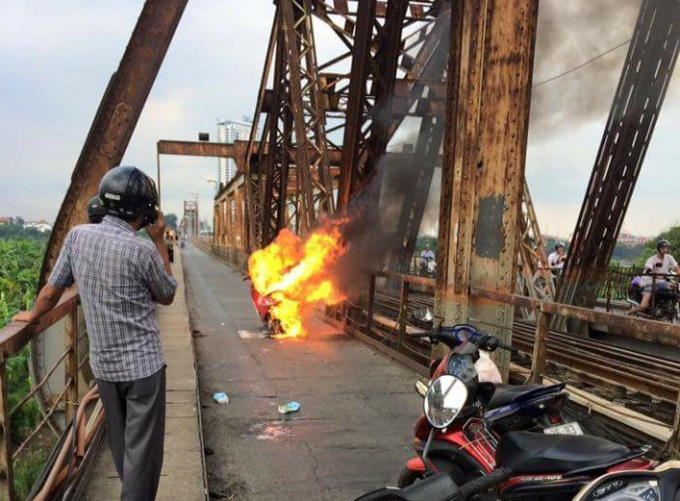 Chiếc xe máy bốc cháy ngùn ngụt trên cầu Long Biên. Ảnh CTV.