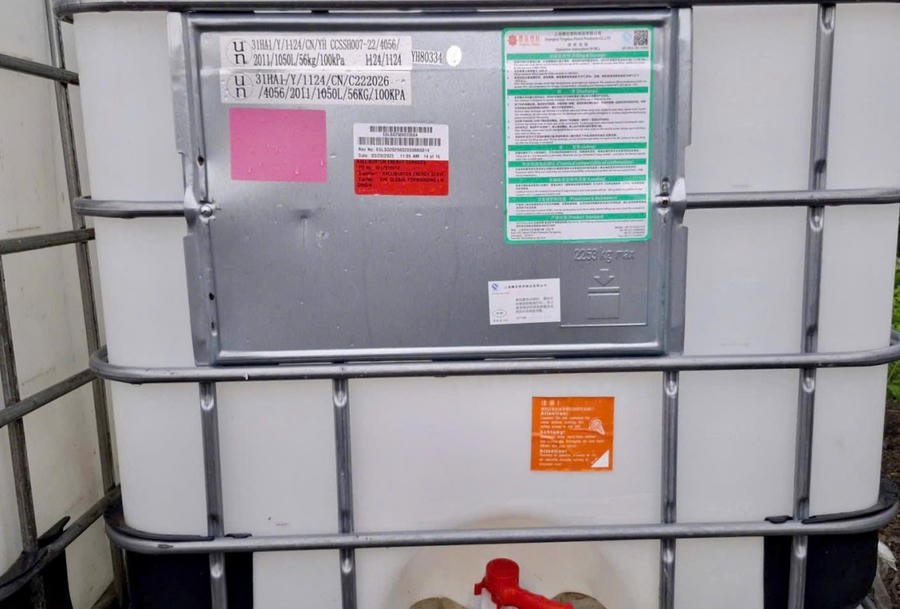 Thùng nhựa lớn, bên ngoài có nhãn và chữ nước ngoài đặt trên đồi Con Heo.