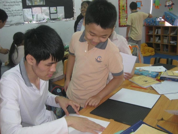 Anh Trần Thế Đạt dạy chữ nổi cho trẻ khuyết tật.