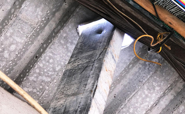 Một thanh sắt to, dài khoảng 6m bất ngờ lao thẳng từ tầng 9 của công trình xuống, đâm xuyên qua mái tôn, vào trong phòng của người dân. Ảnh Dân trí.