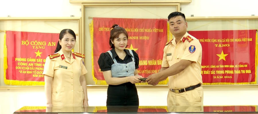 Thượng úy Phạm Cao Bằng bàn giao tai sản cho chị Lê Thị Oanh. (Ảnh: Công an Ninh Bình)