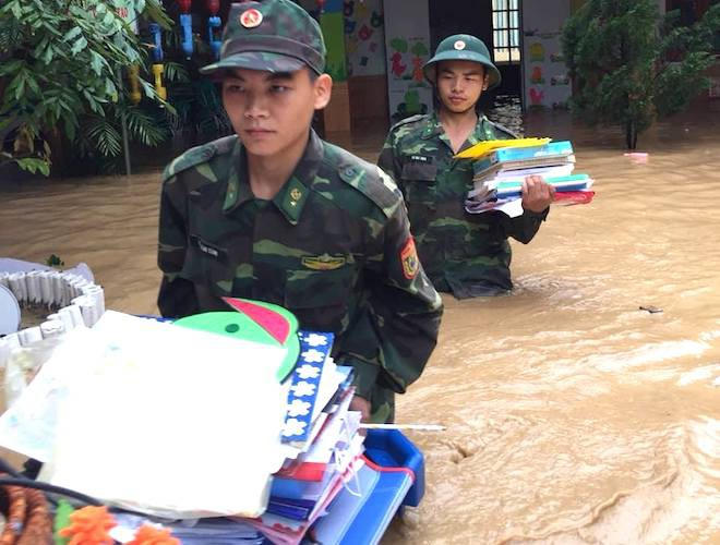 Giúp trường mầm non di chuyển tài sản, thiết bị dạy học ra khỏi ngập lụt.(Ảnh: Hải Thượng).