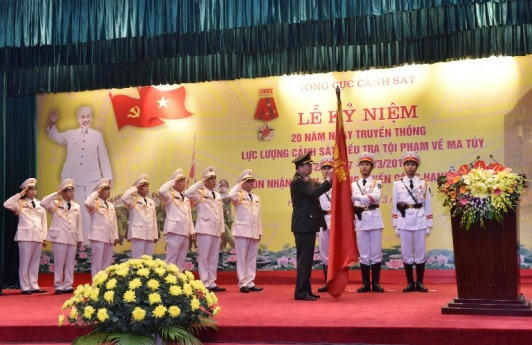 Bộ trưởng Bộ công an Tô Lâm gắn huân chương chiến công hạng Nhấy lên cờ truyền thống của Cục cảnh sát ĐTTP về ma túy