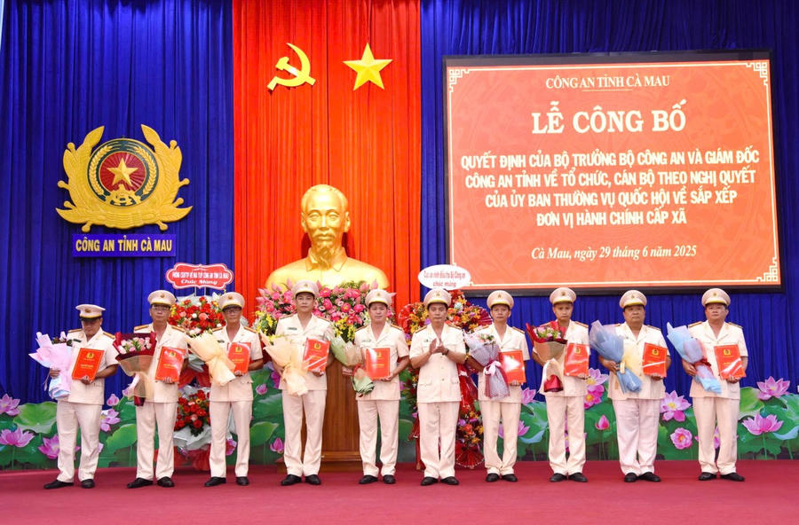 Đại tá Bùi Xuân Khởi - Phó Giám đốc Công an tỉnh Cà Mau, trao quyết định và tặng hoa chúc mừng các Trưởng Công an xã.