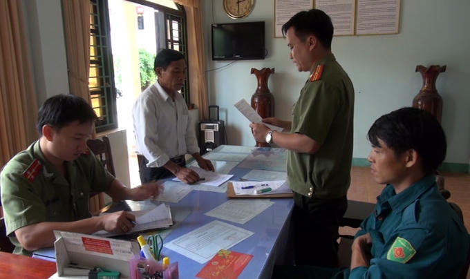 Đoàn Quốc Dũng (áo trắng) nghe quyết định khởi tố