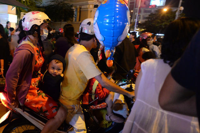 Nhiều gia đình chở nhau đi vào trung tâm thành phố và tắc cứng không thể di chuyển. Trẻ nhỏ mệt mỏi trong đám đông khói bụi và tiếng ồn.