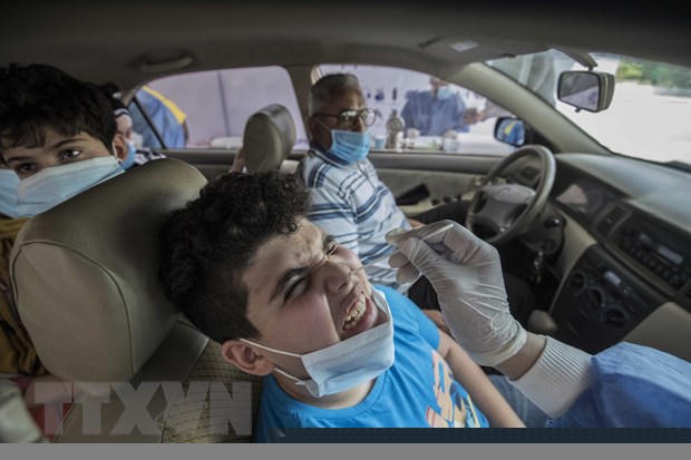 Nhân viên y tế lấy mẫu xét nghiệm COVID-19 tại Cairo, Ai Cập. (Ảnh: AFP/TTXVN)