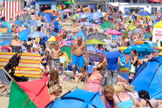 Thời tiết nắng nóng cực điểm và khô hạn khiến số người đến bể bơi để tránh nóng tăng vọt lên mức kỷ lục. Hình ảnh: Bãi biển chật như nêm trong thời tiết nắng nóng bờ biển hạt Dorset Tây Nam nước Anh - REX/Shutterstock