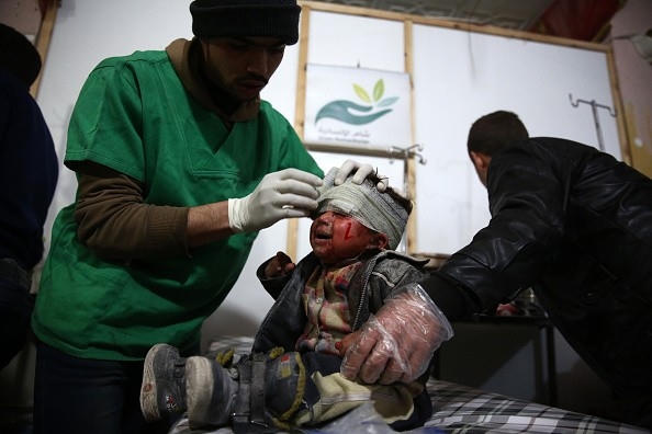 Nhân viên y tế đang băng bó cho một bé trai Syria bị thương khi lực lượng chính phủ tấn công thị trấn Douma do phe nổi dậy kiểm soát. Ảnh: Getty.