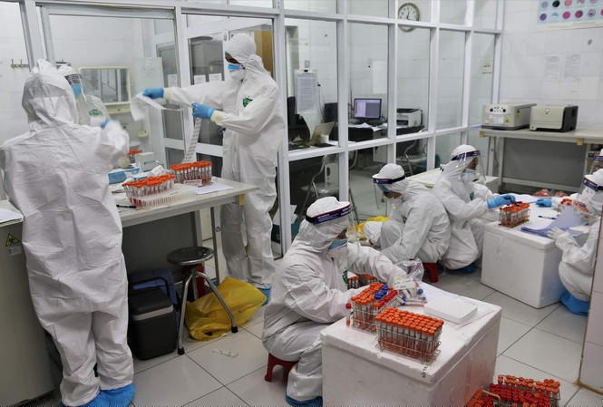 Nhân viên y tế lấy mẫu xét nghiệm COVID-19. Ảnh: T.Hà