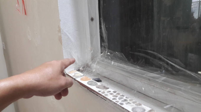 Sau khi bơm keo silicon vào khe cửa, các hộ dân phải gia cố thêm băng dính nhưng vẫn không ngăn được mùi lạ tấn công.